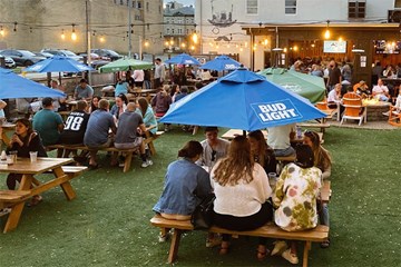 Tennessee Avenue Beer Hall Outdoor area with table seating with umbrellas and outside bar.