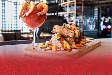 Mother's Day food specials at Amada - Bloody Mary cocktail with cooked shrimp. And Seafood entree on wooden cutting board.