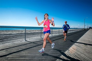 Two runners run on the Boardwalk next to the beach and ocean at the April Fools Half Marathon in Atlantic City.