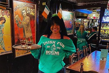 Irish Pub waitress dressed for St. Patrick's Day holding a tray of Irish cheer!